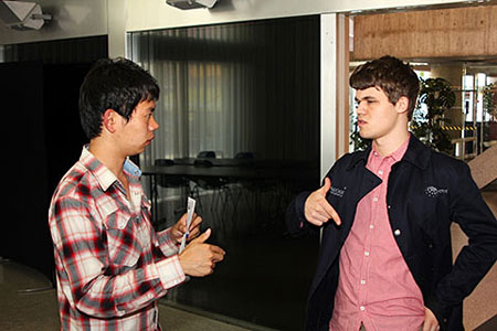 Wang Hao y Carlsen discutiendo la partida 