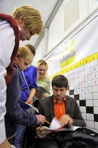 El séptublo campeón ruso Peter Svidler con jóvenes aficionados ávidos de autógrafos
